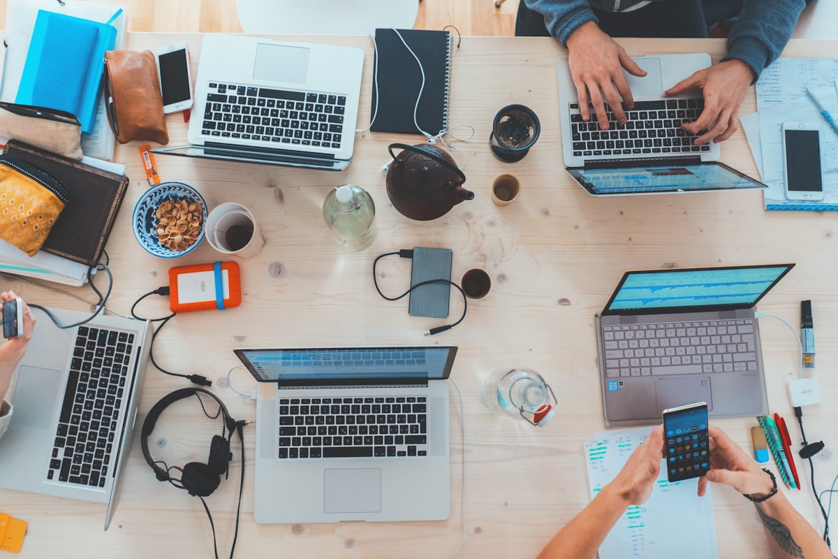Équipe en train de prospecter, ordinateurs et téléphones sur un bureau